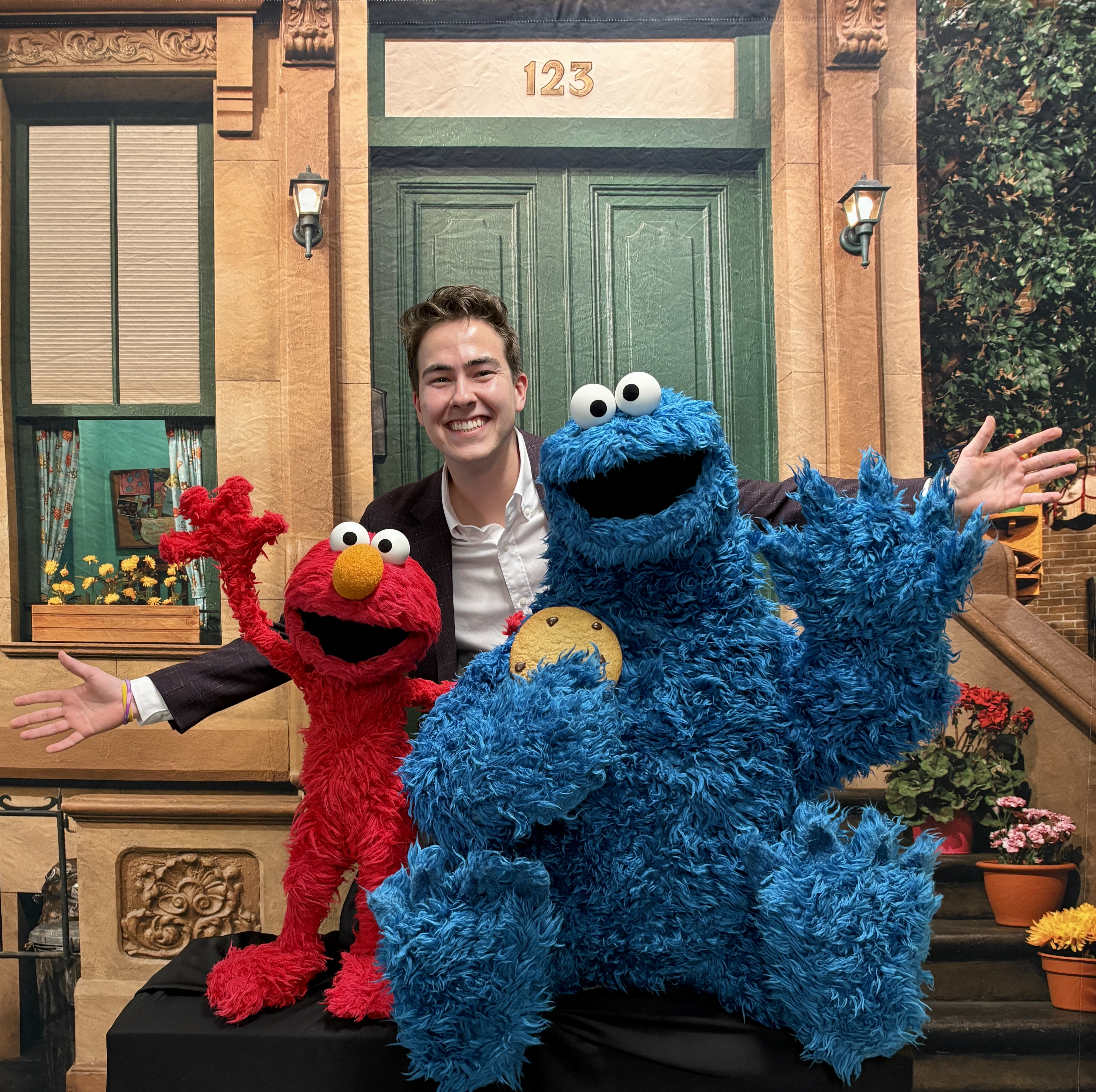 Caleb posing with Elmo and Cookie Monster